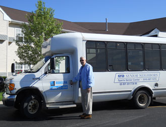 Image of a bus driver smiling outside of the bus - Full transportation list for general public
